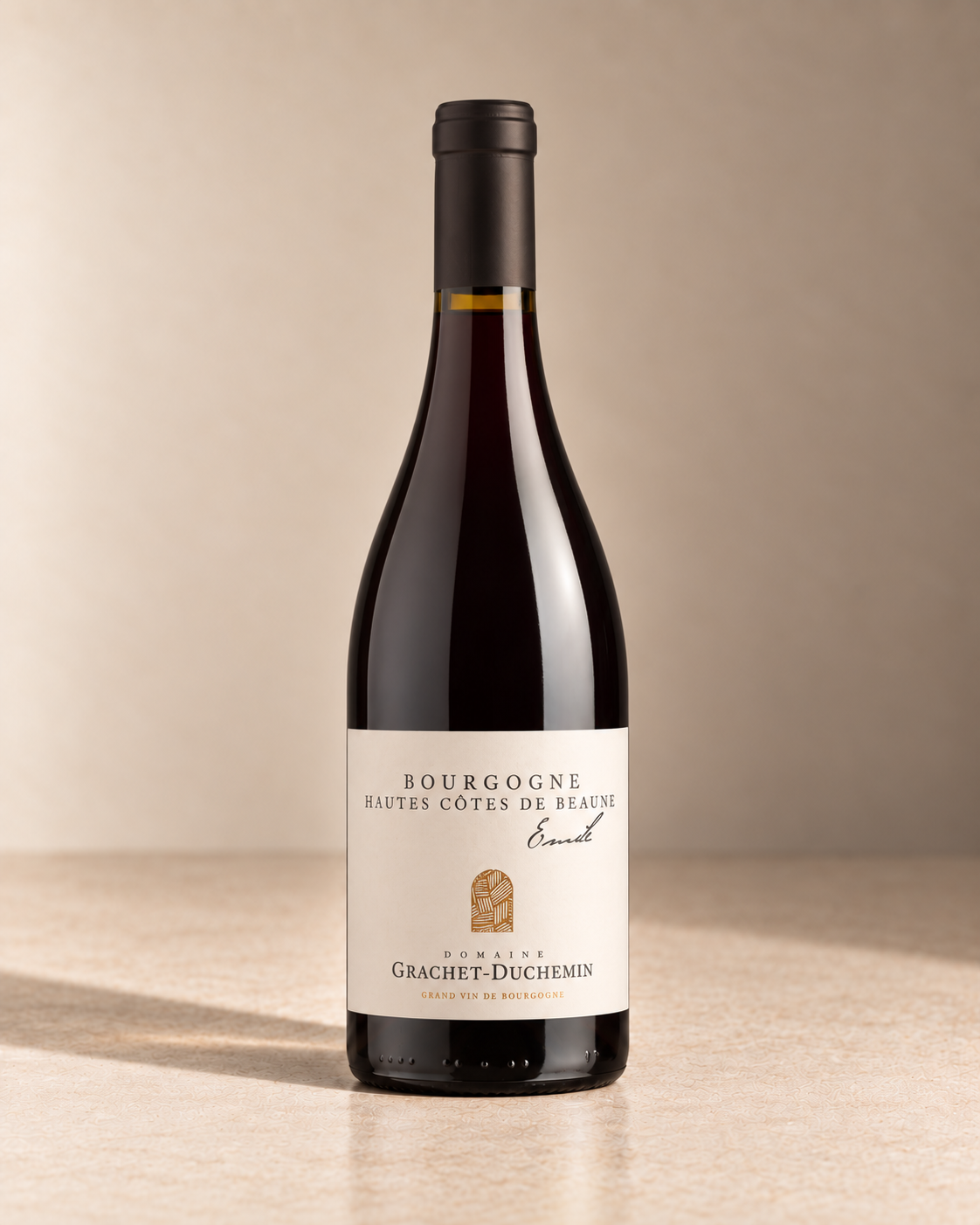 'Emile' Hautes-Côtes de Beaune 2023 single wine bottle on a warm beige studio background