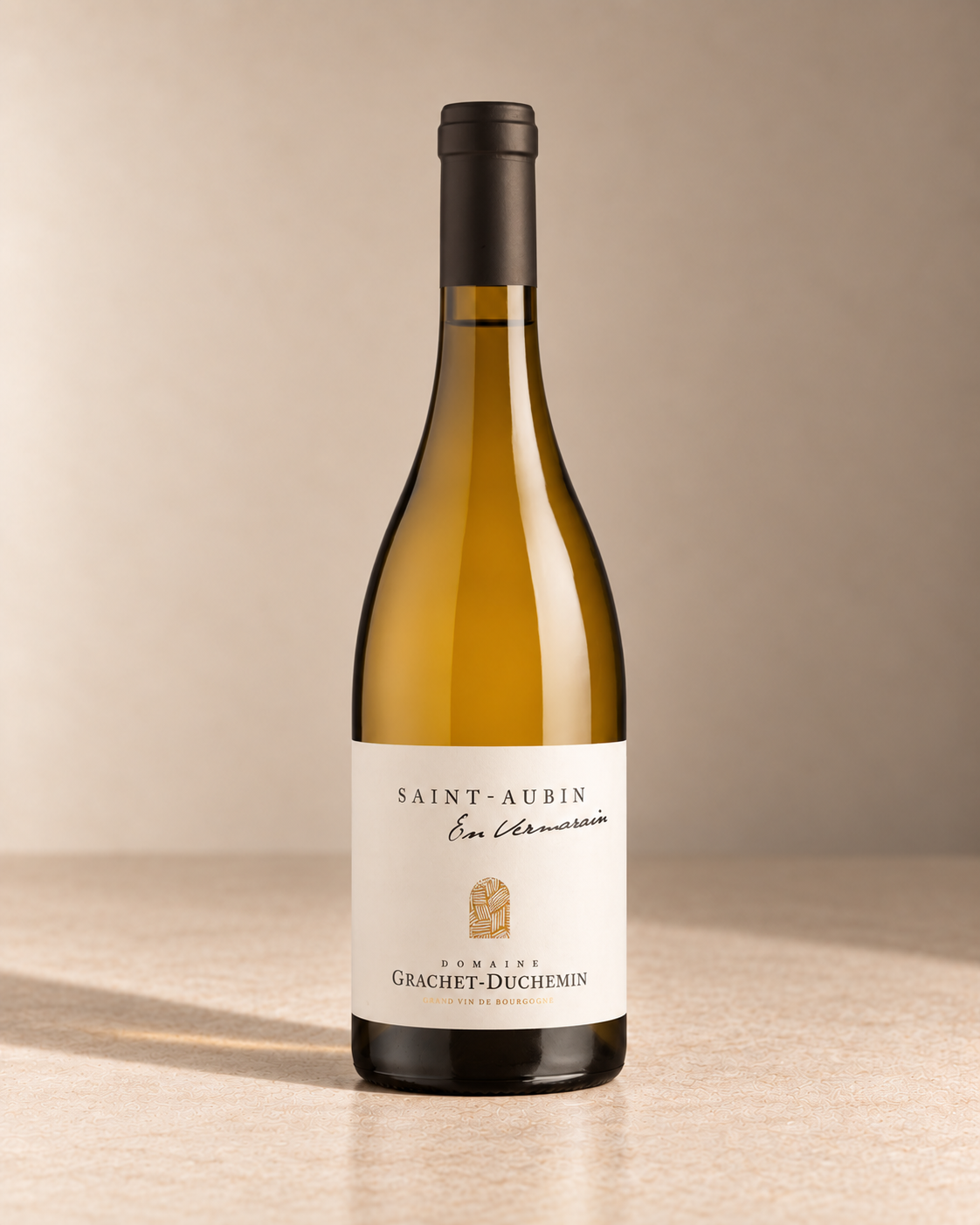 'En Vermarain' St Aubin 2024 single wine bottle on a warm beige studio background