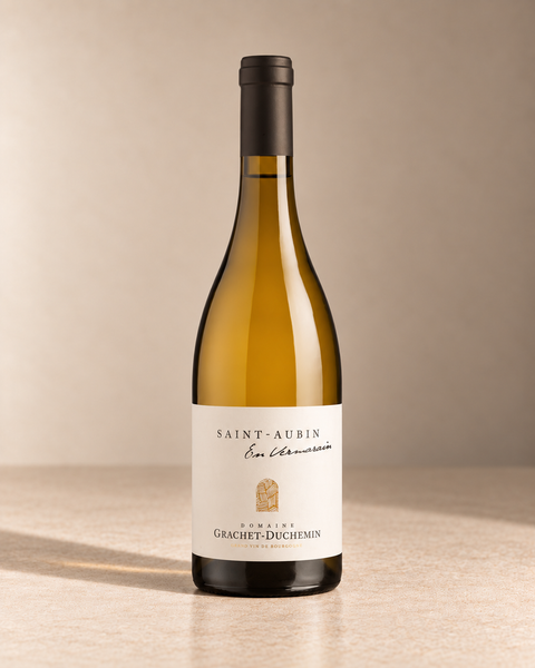 'En Vermarain' St Aubin 2024 single wine bottle on a warm beige studio background