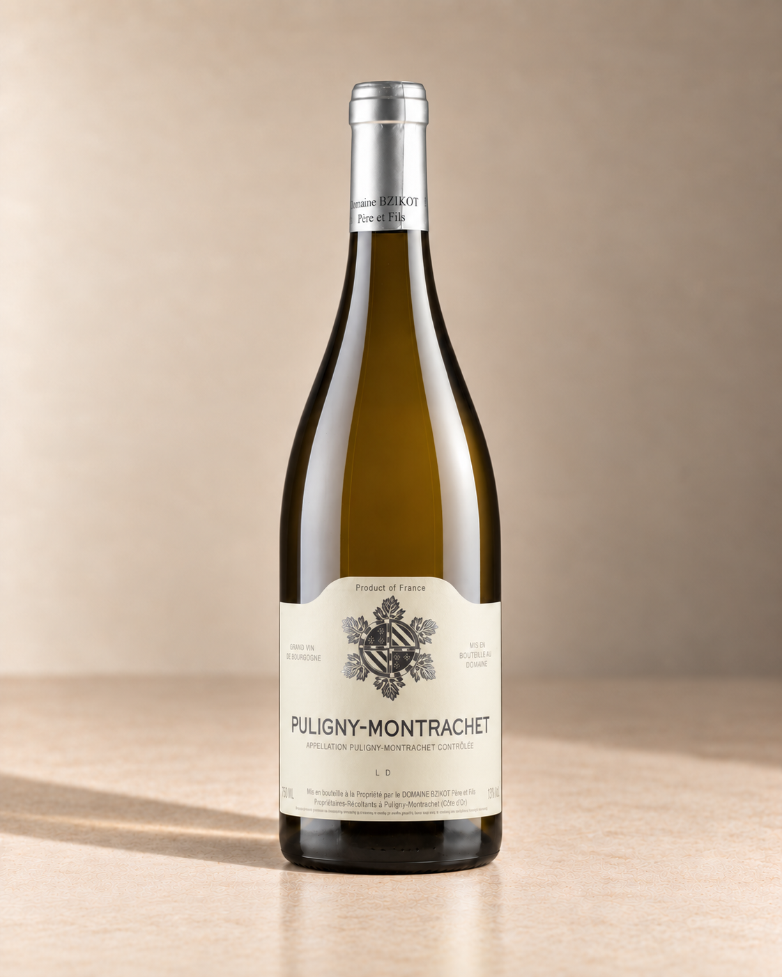Puligny Montrachet 2022 single wine bottle on a warm beige studio background