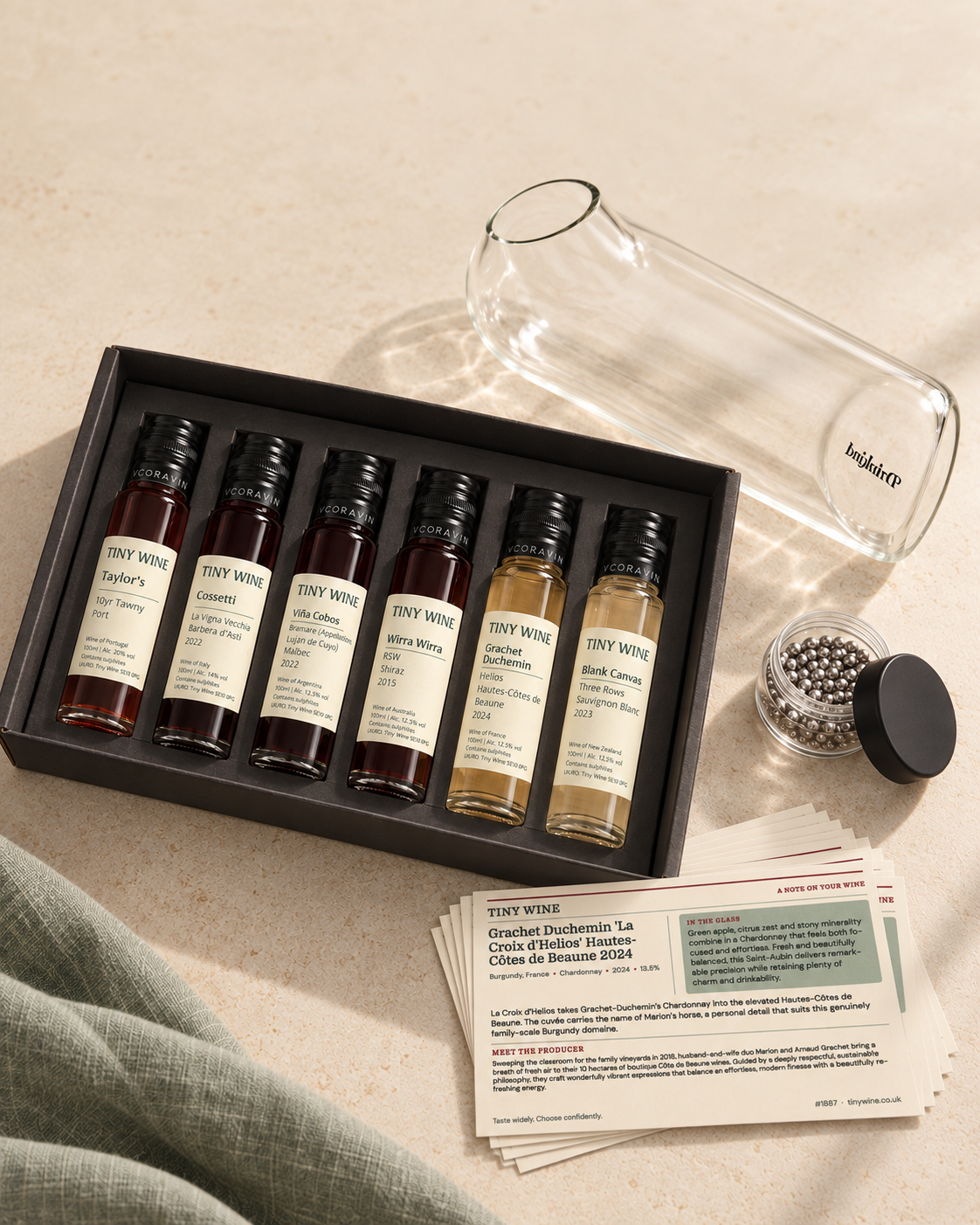 An original wine bottle beside a Tiny Wine 100ml tube