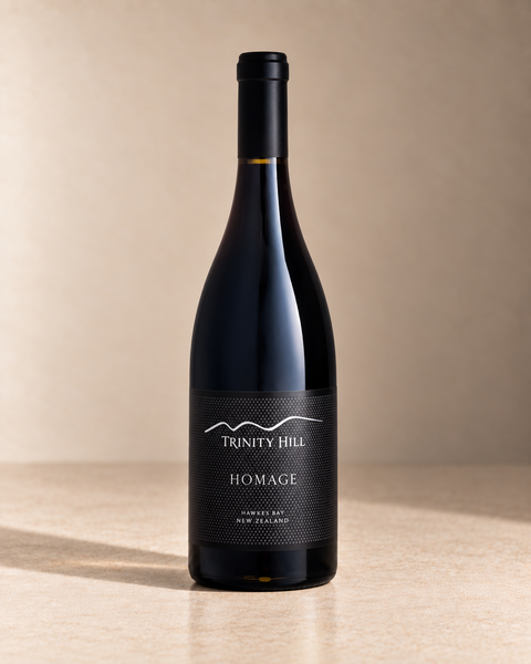 'Homage' Syrah 2016 single wine bottle on a warm beige studio background
