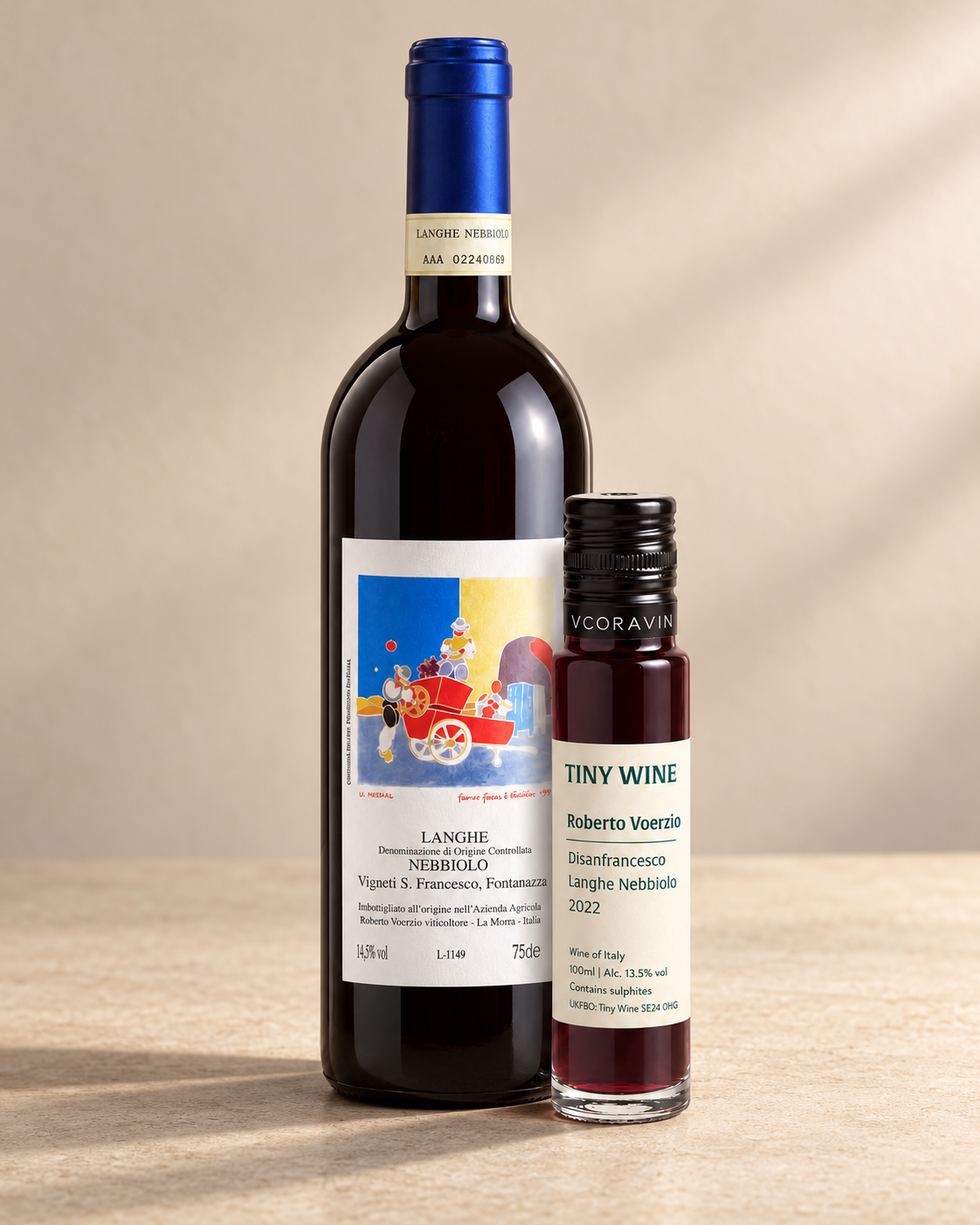 Roberto Voerzio Disanfrancesco Langhe Nebbiolo 2022 bottle and Tiny Wine tasting tube on a warm beige studio background