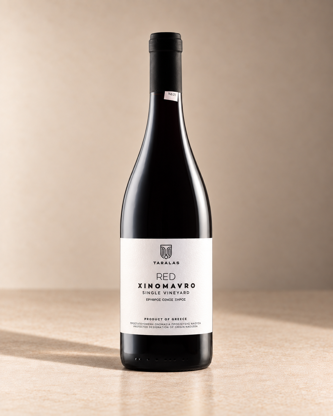 Xinomavro 2012 single wine bottle on a warm beige studio background
