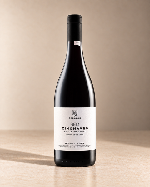 Xinomavro 2012 single wine bottle on a warm beige studio background